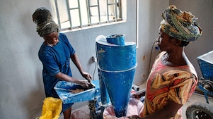 Two women using an electric milling machine