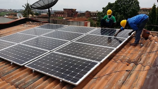 workers installing solar panels on roof
