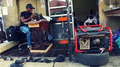 Nigerian man sitting on sewing machine