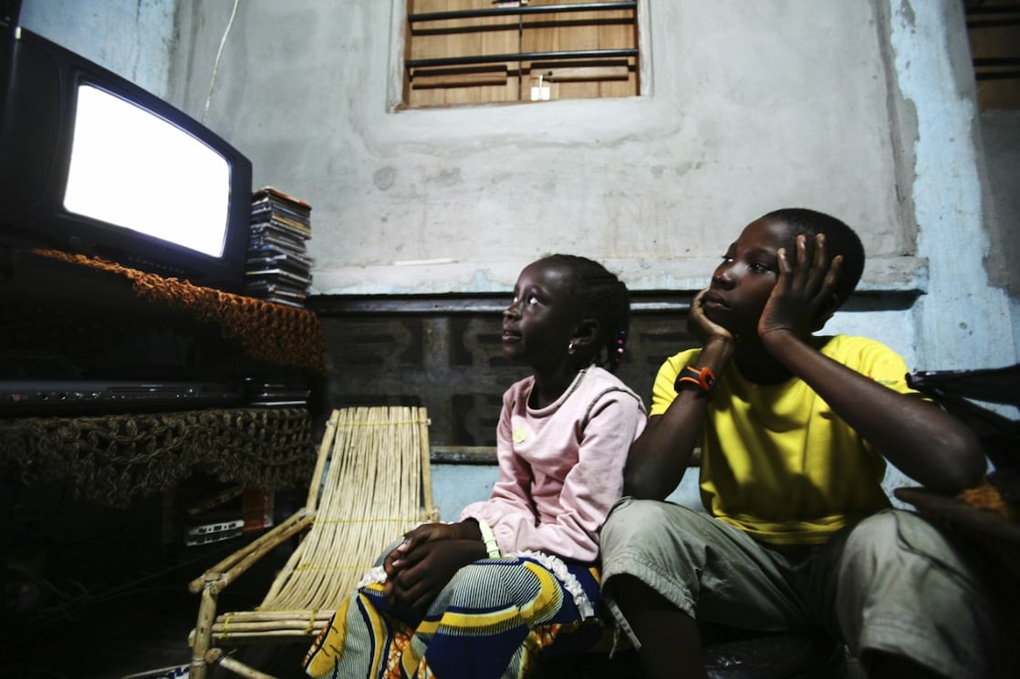 A young man introducing his little brother to data processing, on a laptop