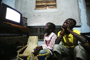 A young man introducing his little brother to data processing, on a laptop